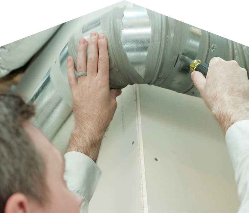 Moore & Russell HVAC technician inspecting and tightening a joint on a sealed metal air duct, performing maintenance work during an air duct cleaning task. Moore & Russell HVAC technician inspecting and tightening a joint on a sealed metal air duct, performing maintenance work during an air duct cleaning task.