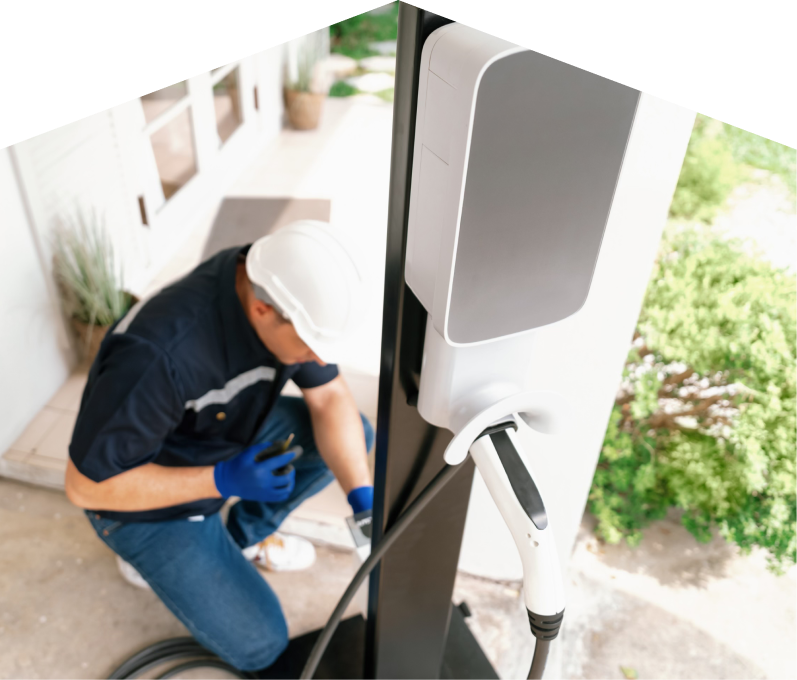 Home service electrician from Moore & Russell installing an EV charger fixed to a vertical post near a residential entryway. Home service electrician from Moore & Russell installing an EV charger fixed to a vertical post near a residential entryway.