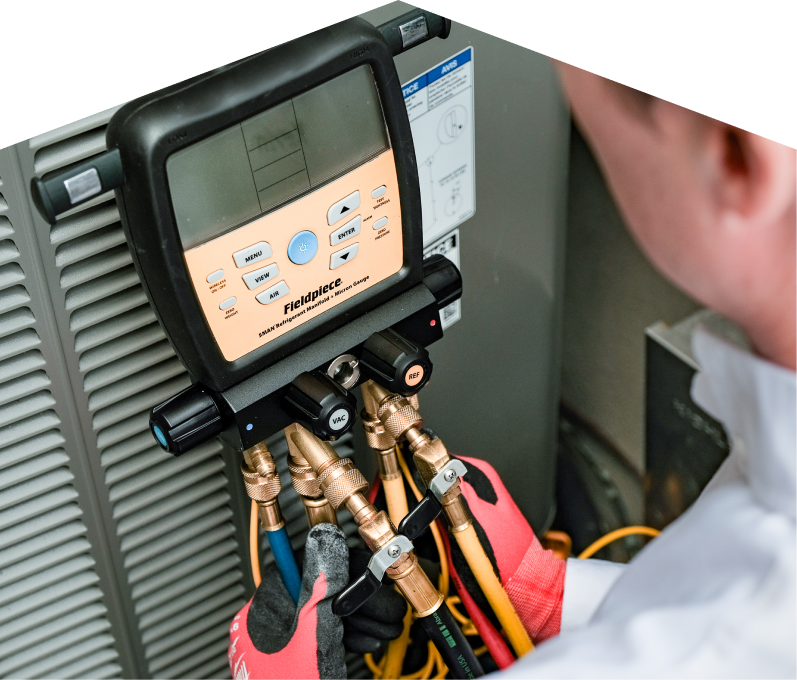 A Moore & Russell home service crew member uses a digital manifold gauge to check refrigerant levels on an HVAC unit for service. A Moore & Russell home service crew member uses a digital manifold gauge to check refrigerant levels on an HVAC unit for service.