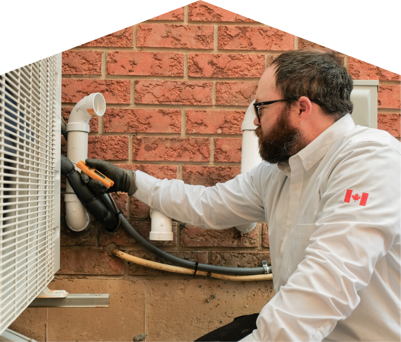 Moore & Russell HVAC specialist checking insulated piping on a heat pump unit beside a brick wall during a diagnostic service. Moore & Russell HVAC specialist checking insulated piping on a heat pump unit beside a brick wall during a diagnostic service.