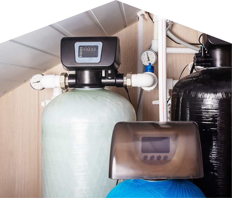 Moore & Russell home water filtration system featuring resin tanks, digital control heads, pressure gauges, and connected piping in a utility room. Moore & Russell home water filtration system featuring resin tanks, digital control heads, pressure gauges, and connected piping in a utility room.