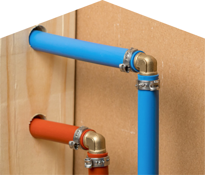 Moore & Russell kitec plumbing system with blue and orange plastic pipes connected by brass fittings and metal clamps, mounted on a wooden panel. Moore & Russell kitec plumbing system with blue and orange plastic pipes connected by brass fittings and metal clamps, mounted on a wooden panel.