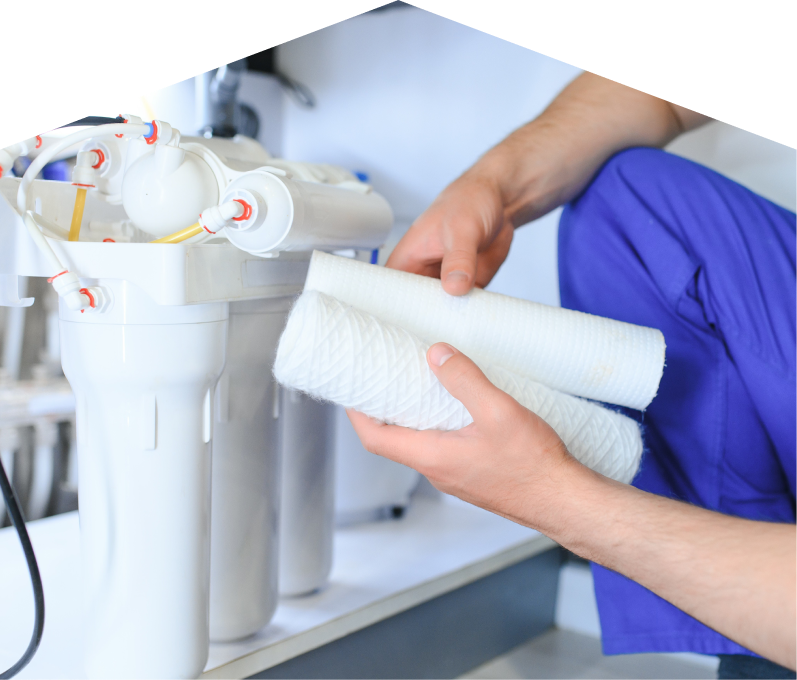 Moore & Russell water filtration specialist replacing filter cartridges on a reverse osmosis water system installed under a sink. Moore & Russell water filtration specialist replacing filter cartridges on a reverse osmosis water system installed under a sink.
