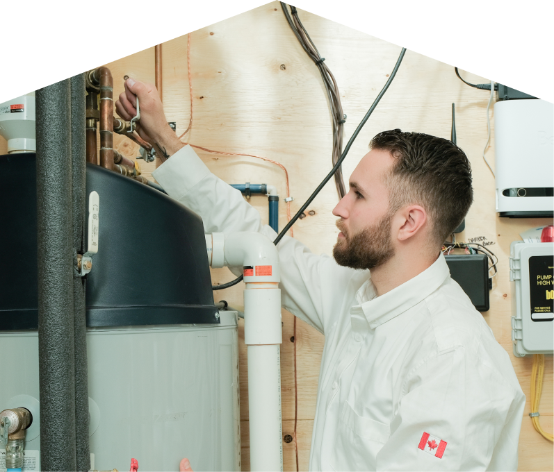 Moore & Russell water heater specialist adjusts piping on a large residential unit during a repair service, with exposed wood paneling and mounted utility components in the background. Moore & Russell water heater specialist adjusts piping on a large residential unit during a repair service, with exposed wood paneling and mounted utility components in the background.